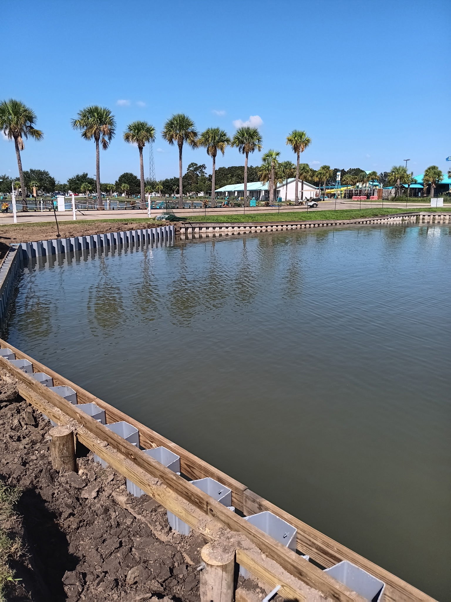 Completed sheet pile bulkhead curving around a lake shoreline in South Louisiana