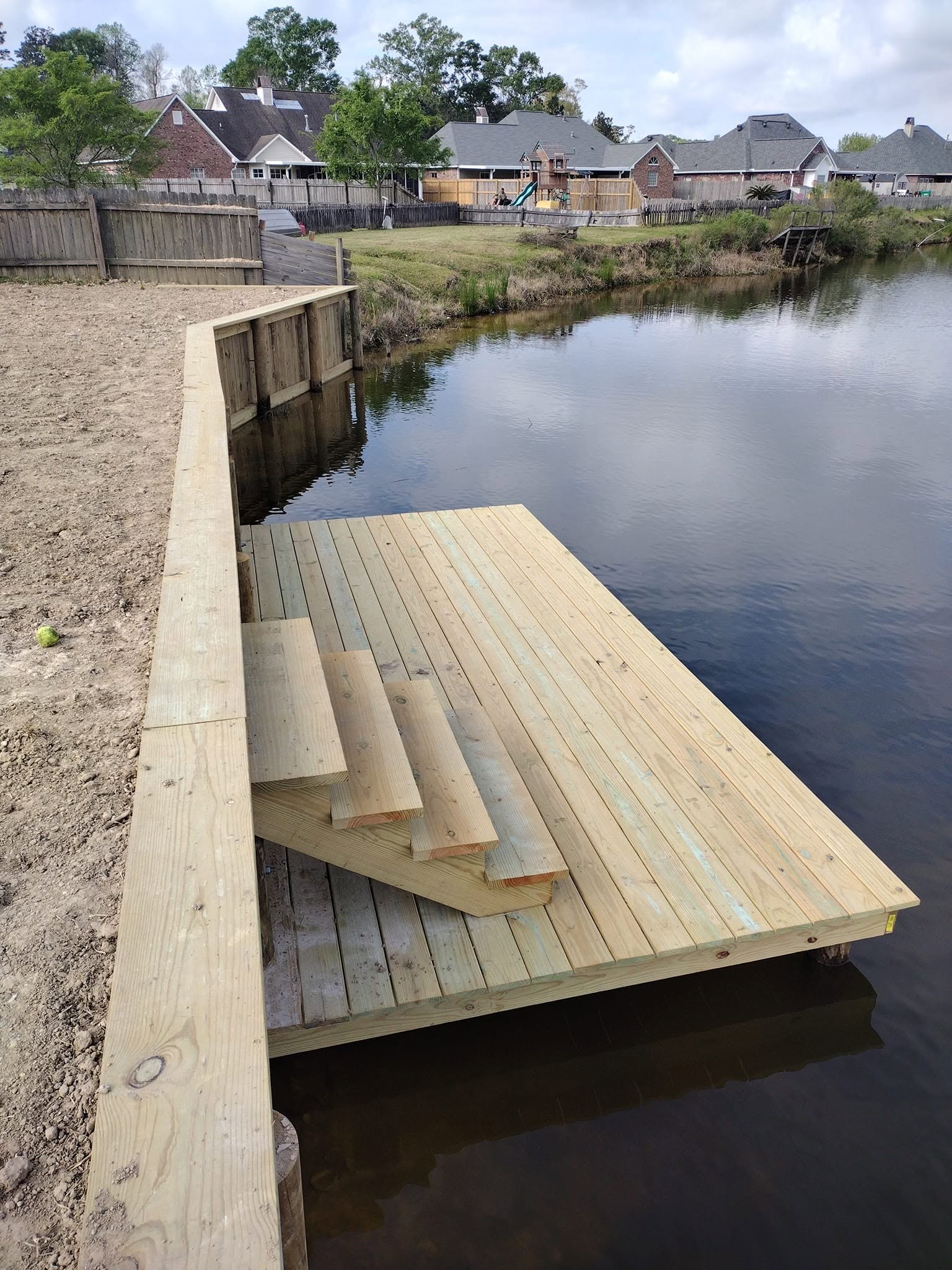 Newly built treated timber bulkhead sea wall holding a graded shoreline on a South Louisiana waterway