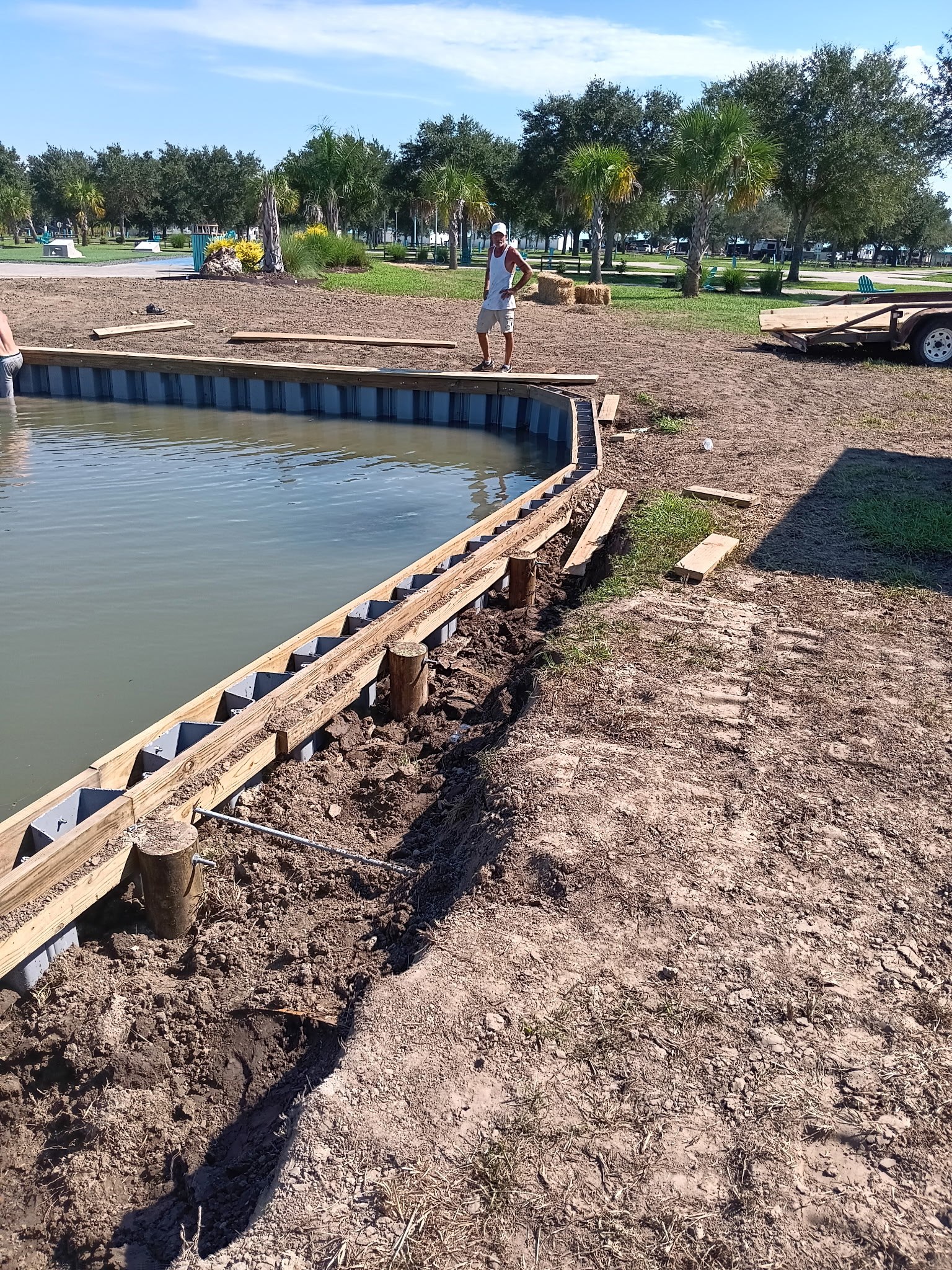 Sheet pile bulkhead installation crew, South Louisiana LA Fence & Bulkheads crew setting sheet pile bulkhead panels along a South Louisiana lake