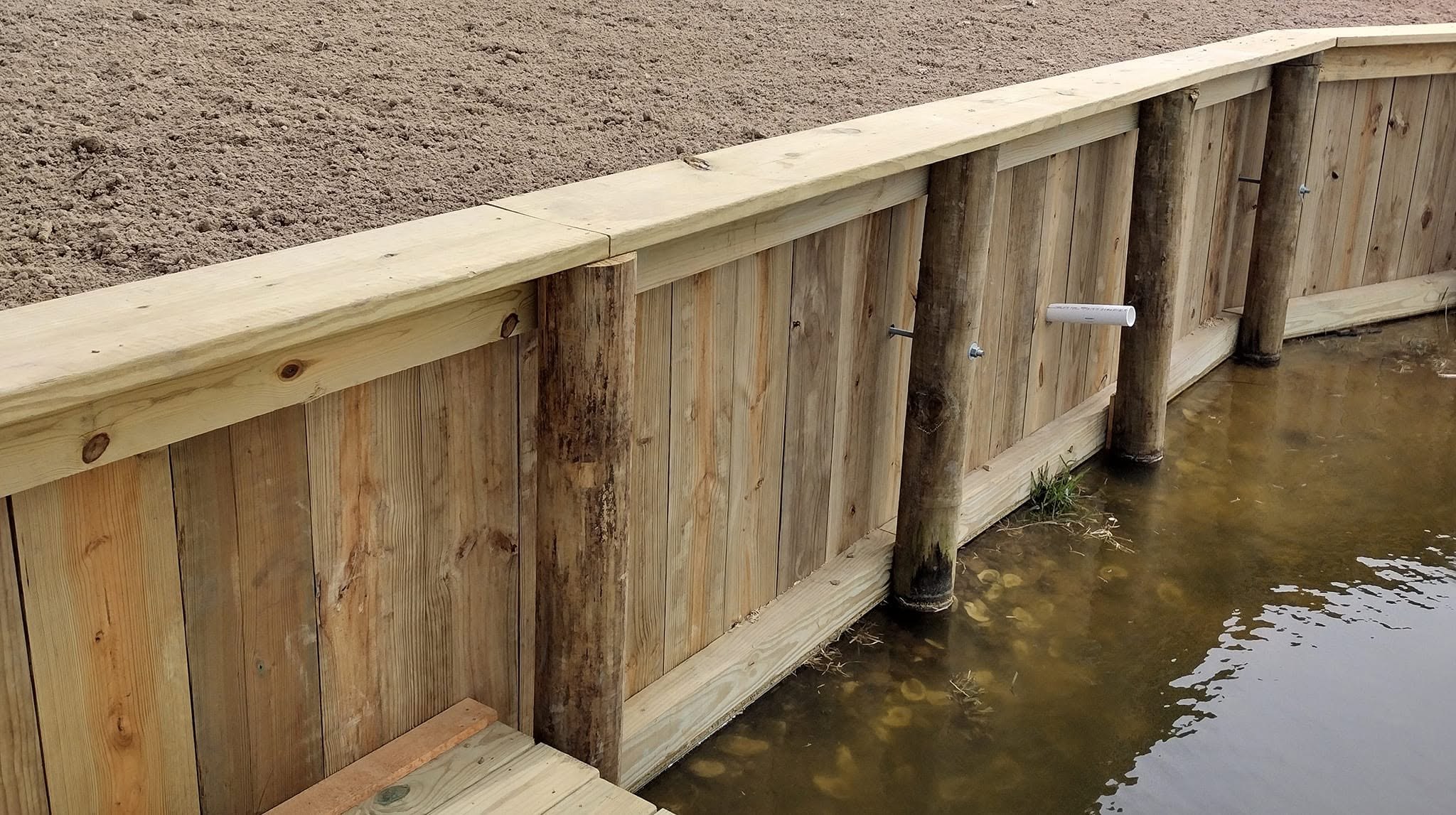 Newly built treated timber bulkhead sea wall holding a graded shoreline on a South Louisiana waterway
