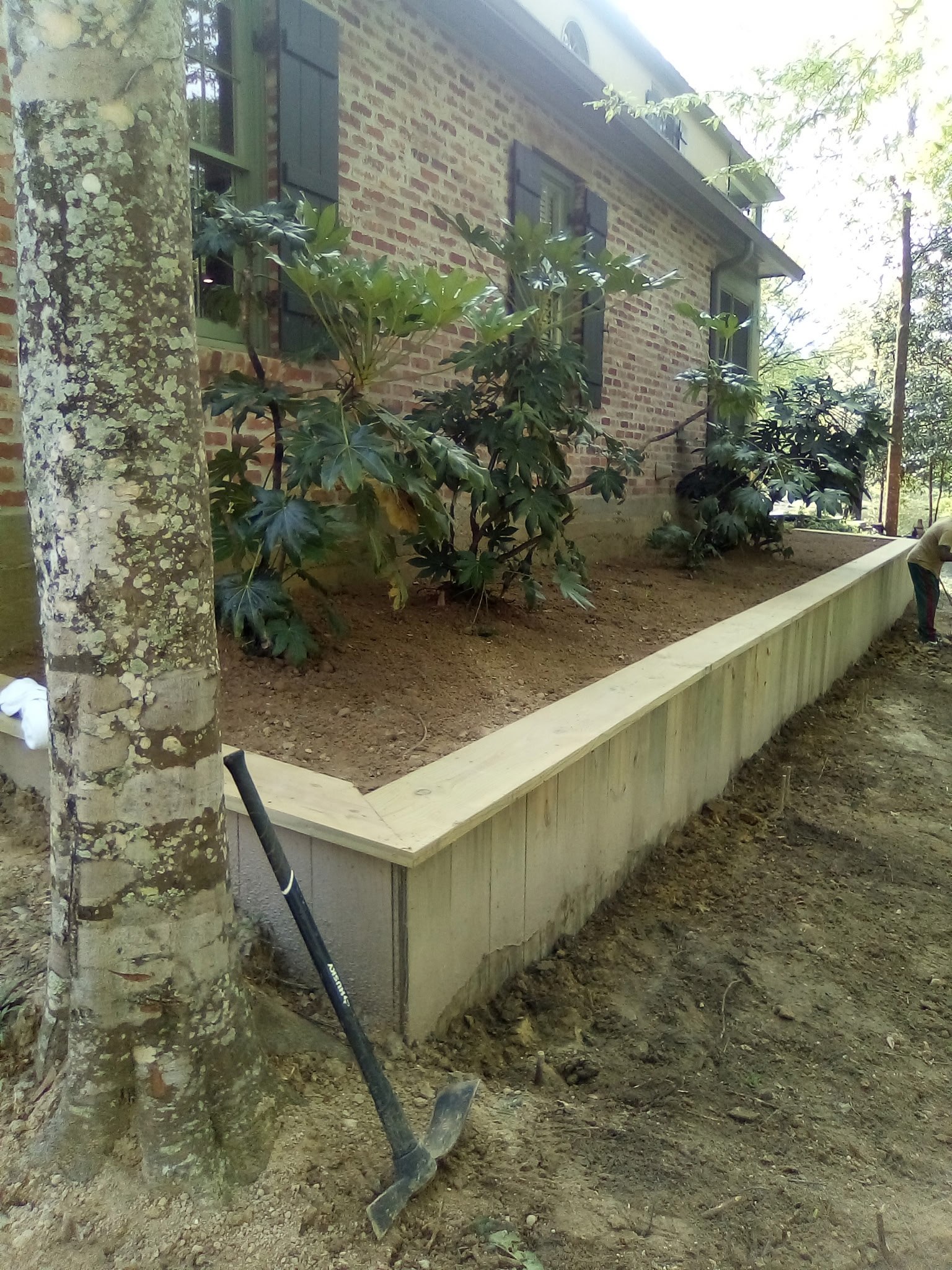 Wood retaining wall built for soil stabilization on a sloped Louisiana property